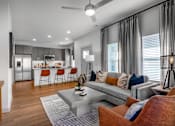 Thumbnail 8 of 52 - A modern living room with a grey couch and a grey coffee table.
