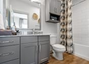 Thumbnail 14 of 52 - A bathroom with a toilet, sink, and a mirror.