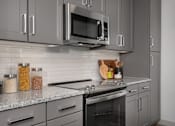 Thumbnail 4 of 52 - A modern kitchen with a stainless steel oven and microwave.