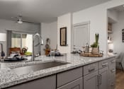 Thumbnail 6 of 52 - A modern kitchen with a marble countertop and a stainless steel faucet.