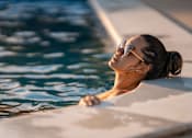Thumbnail 4 of 11 - A woman in sunglasses is relaxing in a pool.