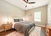 Thumbnail 33 of 33 - A bedroom with a bed, nightstand, and a ceiling fan at Beau Chene Lake Charles Apartments, Los Angeles