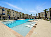 Thumbnail 17 of 33 - A large swimming pool in front of apartment buildings. at Beau Chene Lake Charles Apartments, Lake Charles