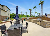 Thumbnail 19 of 33 - A patio with a table and chairs and umbrellas at Beau Chene Lake Charles Apartments, Los Angeles, 70605