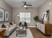 Thumbnail 11 of 12 - a living room with a couch and a ceiling fan at Beau Chene Lake Charles Apartments in Lake Charles, LA 70605