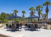 Thumbnail 4 of 12 - a patio area with tables and chairs and umbrellas at Beau Chene Lake Charles Apartments in Lake Charles, LA 70605