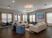 Thumbnail 7 of 12 - clubhouse with couches and chairs and a table at Beau Chene Lake Charles Apartments in Lake Charles, LA 70605