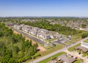 Thumbnail 2 of 12 - an aerial view of a parking lot with buildings and trees at Beau Chene Lake Charles Apartments in Lake Charles, LA 70605
