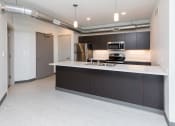 Thumbnail 15 of 81 - Modern open-concept kitchen and living area with stainless steel appliances.