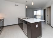 Thumbnail 22 of 81 - Modern open-concept kitchen and living area with stainless steel appliances.