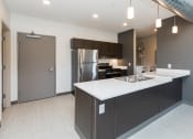 Thumbnail 31 of 81 - Modern open-concept kitchen and living area with stainless steel appliances.