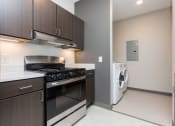 Thumbnail 33 of 81 - Modern open-concept kitchen and living area with stainless steel appliances.