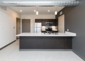 Thumbnail 39 of 81 - Modern open-concept kitchen and living area with stainless steel appliances.