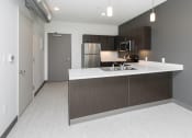 Thumbnail 51 of 81 - Modern open-concept kitchen and living area with stainless steel appliances.
