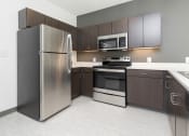 Thumbnail 53 of 81 - Modern open-concept kitchen and living area with stainless steel appliances.