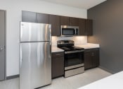 Thumbnail 76 of 81 - Modern open-concept kitchen and living area with stainless steel appliances.