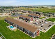 Thumbnail 60 of 72 - an aerial view of an apartment complex with cars parked in a parking lot