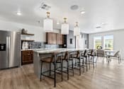 Thumbnail 40 of 44 - an open kitchen and dining area with a large island and chairs