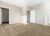 Thumbnail 15 of 54 - A room with a carpeted floor and two open doors.
