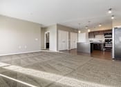 Thumbnail 25 of 54 - A spacious room with a kitchen area in the background.