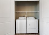 Thumbnail 27 of 54 - A white laundry room with a washer and dryer.