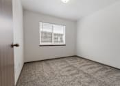 Thumbnail 6 of 57 - A room with a carpeted floor and a window with blinds.