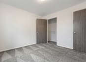 Thumbnail 29 of 50 - A room with a carpeted floor and two doors.