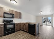 Thumbnail 4 of 50 - A kitchen with wooden cabinets and black appliances.