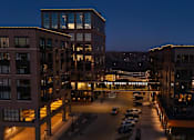 Thumbnail 25 of 41 - A view of a parking lot and buildings at night.