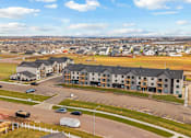 Thumbnail 41 of 44 - A large building complex with a parking lot in front.