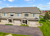 Thumbnail 60 of 64 - A house with a grey roof and a grey garage door.