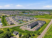 Thumbnail 7 of 44 - A bird's eye view of a residential area with houses and green spaces.