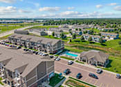 Thumbnail 31 of 31 - A large apartment complex with a swimming pool and a parking lot.