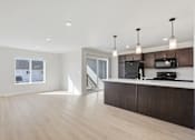 Thumbnail 2 of 68 - A modern kitchen with dark wood cabinets and a white countertop.