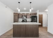 Thumbnail 3 of 44 - a kitchen with a marble counter top and a black refrigerator