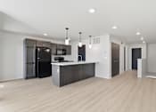 Thumbnail 8 of 68 - A kitchen with a black fridge and microwave, a white counter, and a black cabinet.
