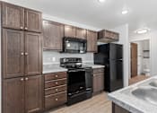 Thumbnail 5 of 44 - a kitchen with black appliances and wooden cabinets
