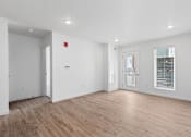 Thumbnail 4 of 44 - the living room of an apartment with white walls and wood floors