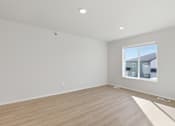 Thumbnail 14 of 68 - A room with a window and wooden flooring.