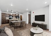 Thumbnail 8 of 44 - A modern living room with a kitchen area in the background.