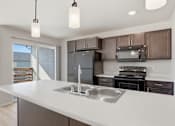 Thumbnail 16 of 68 - A modern kitchen with a large island and stainless steel appliances.