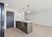 Thumbnail 18 of 68 - A modern kitchen with a dark grey door and wooden flooring.