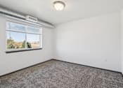 Thumbnail 9 of 21 - A room with a window and a carpeted floor.