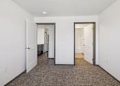 Thumbnail 12 of 21 - A hallway with carpeted floors and white walls.