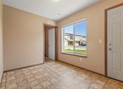 Thumbnail 19 of 64 - A room with a tiled floor and a view of a building outside the window.