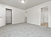 Thumbnail 30 of 60 - A spacious room with white walls and carpeted floor.