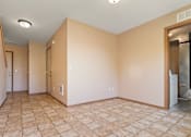 Thumbnail 15 of 64 - A room with tiled flooring and a refrigerator in the corner.