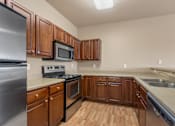 Thumbnail 1 of 40 - A kitchen with wooden cabinets and stainless steel appliances.