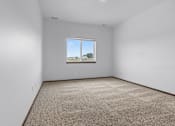 Thumbnail 45 of 54 - A room with a carpeted floor and a window showing a view of the outside.