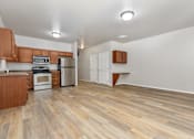 Thumbnail 16 of 60 - A kitchen with wooden floors and white walls.